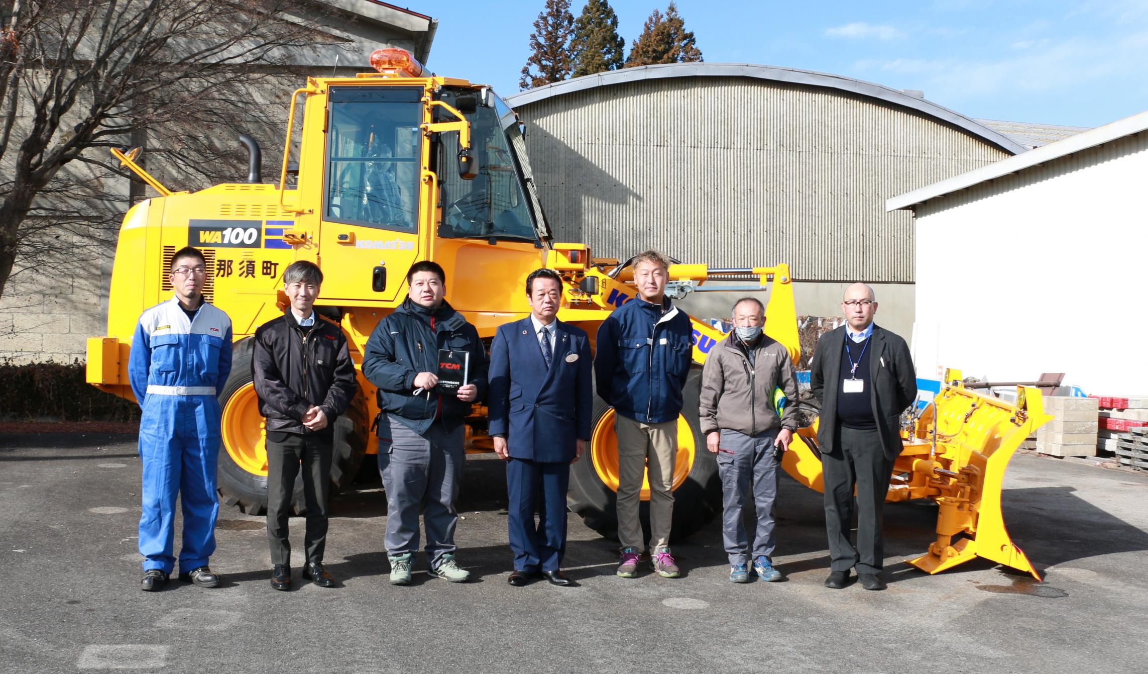 新しく納品された除雪車と除雪事業者の写真