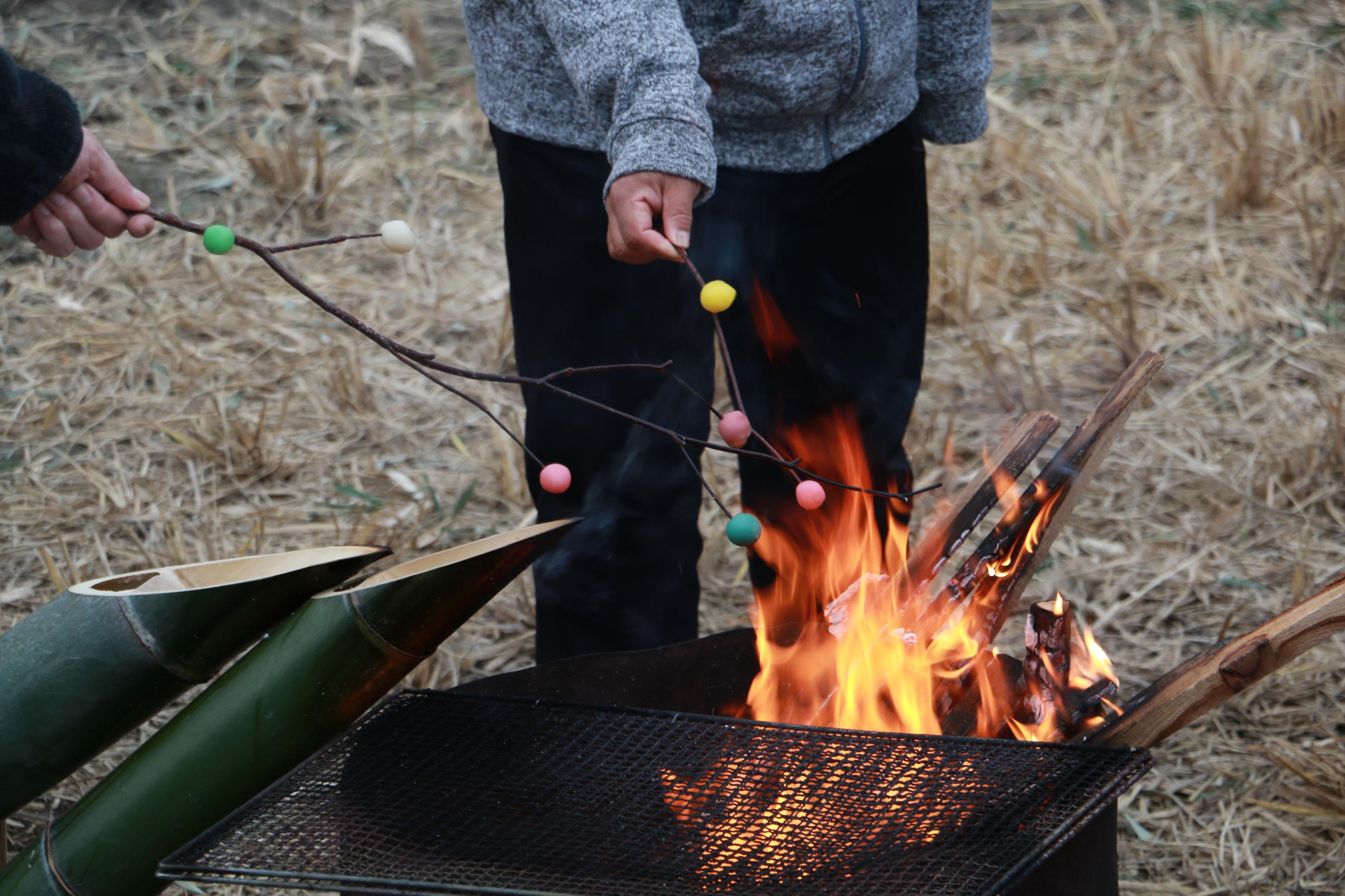 とんぼ団子を焚火で焼いている写真