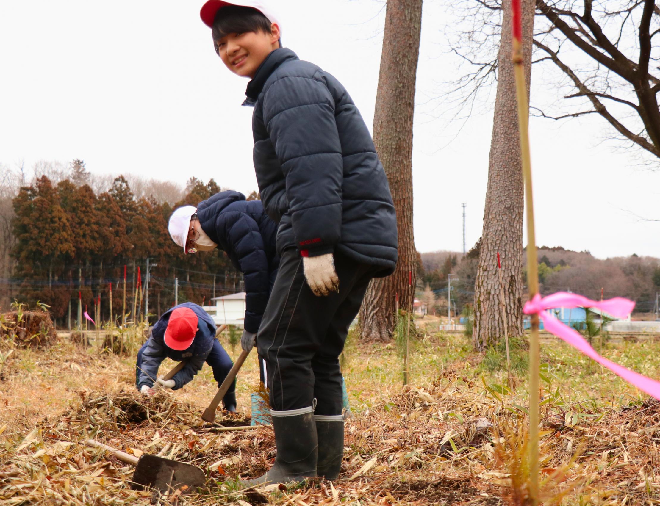 那須街道のアカマツ林にアカマツの苗を植樹している高久小学校の児童の写真