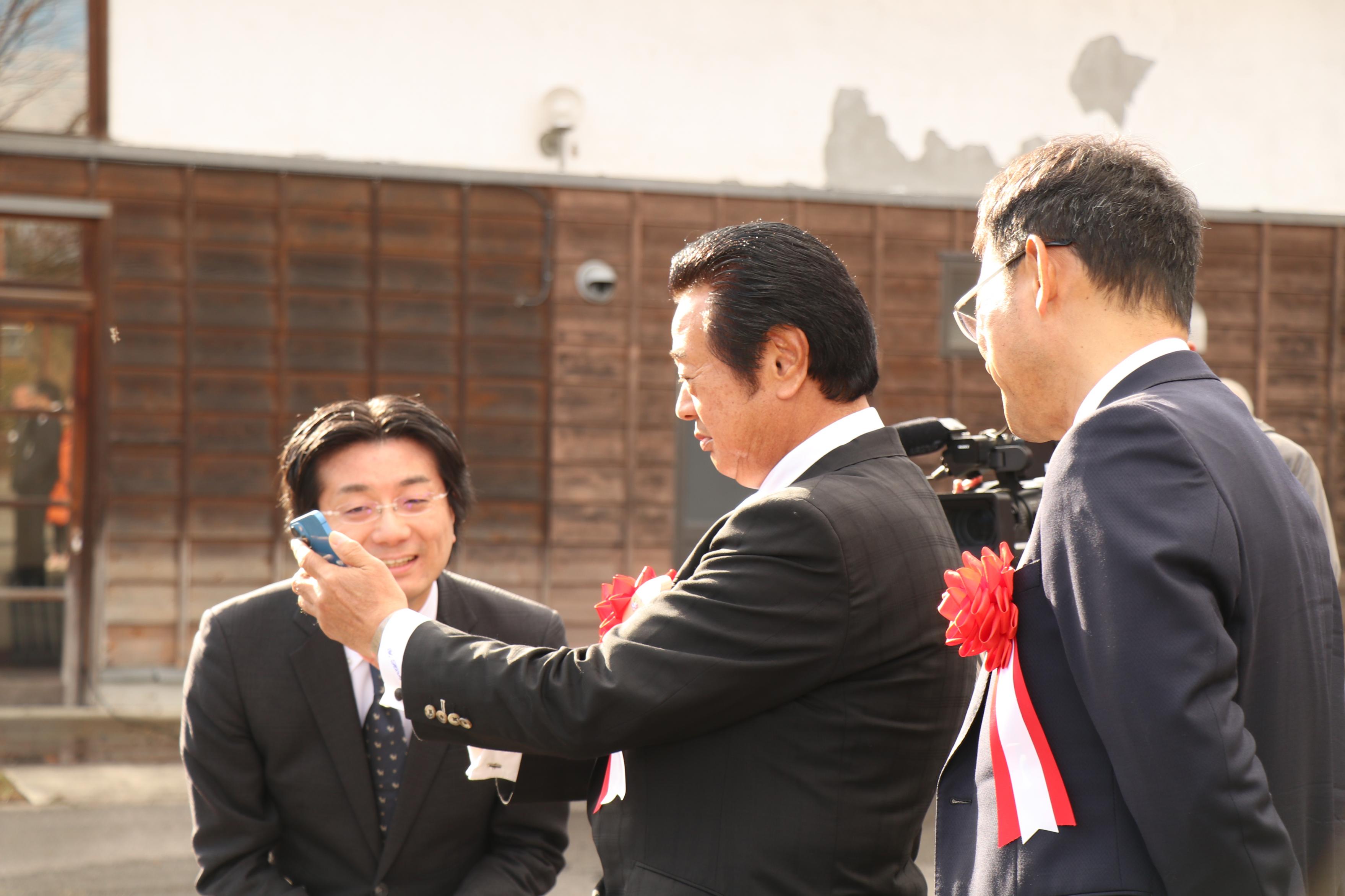 平山町長がスマホ画面でライドシェアの自動車を呼ぶ様子